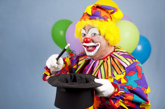 生日快乐小丑玩魔术用顶帽子和魔杖图片