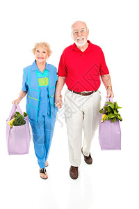 有环保意识的老年夫妇用可重复使的袋子把食品带回家图片