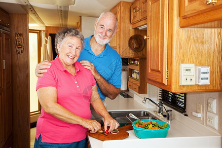 老年夫妇一起在他们的运动之家厨房做饭图片