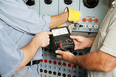 实际电工团队在业电力分配中心测试电压所有工作都按照业守则和安全标准进行给检查员注意仪表上的OHMS字是一个浮度单位不是商标背景图片