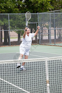 高级女子对赢得网球比赛很兴奋图片