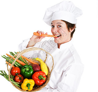 快乐的女厨师拿着一篮新鲜的有机本地生产农品吃着生胡萝卜图片