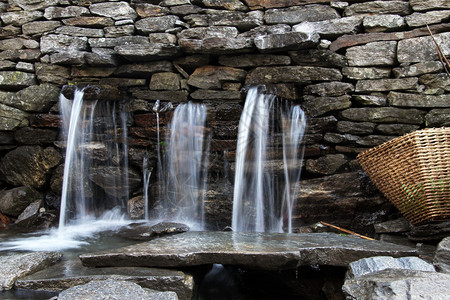 尼泊尔村庄饮用水和石墙图片