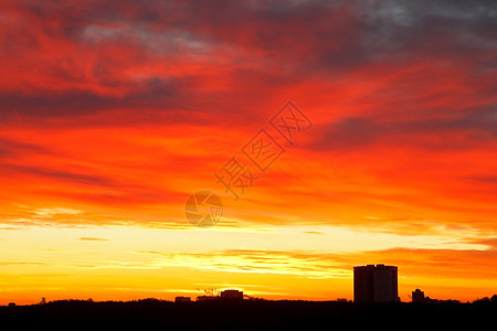 城市房屋的日出天空中闪亮的红色黄蓝的乌云图片