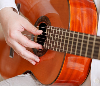 男人在典型的音响吉他上演奏图片
