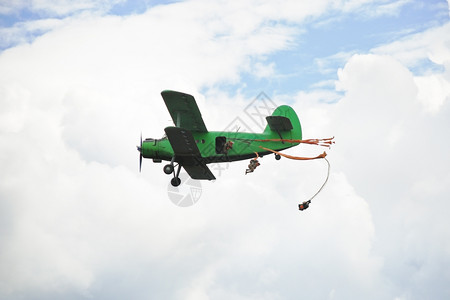 小型绿色飞机驾驶员跳伞背景图片