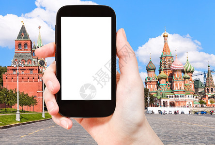 旅行概念手持智能机用剪断的屏幕和Vasilevsky背景的圣巴西尔大教堂红广场的Vasilevsky血统背景图片