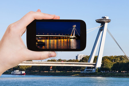 旅行概念SNP桥UFONovyMost新桥在布拉迪斯发多瑙河上用智能手机对SNP桥UFO新的旅游快照图片