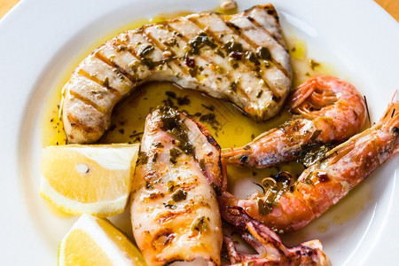 前往意大利菜食西里岛近欧的白色盘子上西里烤鱼和海鲜混合食品图片