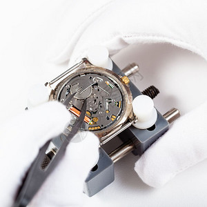 Watchmaker车间用石英手表替换电池由白色背景的tweezers关闭图片