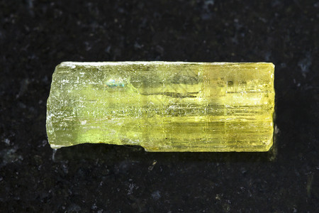 天然矿物岩石标本的宏观拍摄俄罗斯外贝加尔ZabaykalyeSherlovaGora矿深色花岗岩背景上Heliodor黄绿柱石宝图片