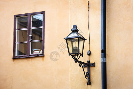 旧街灯和黄色墙上的窗户图片