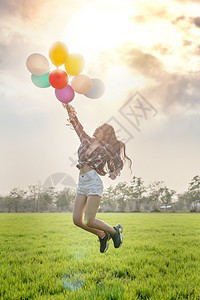 一个快乐的漂亮女人肖像在绿地有气球快乐的漂亮女人气球图片
