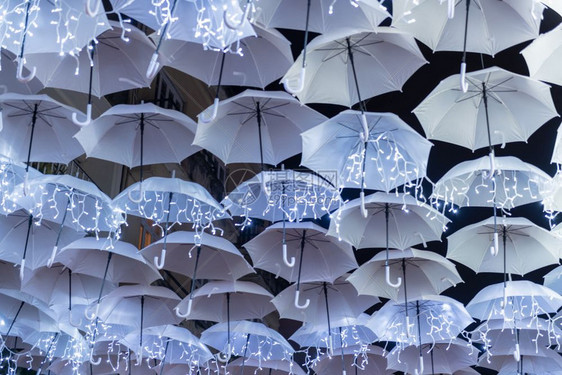 白色雨伞的美丽由圣诞灯照亮装饰着阿圭达葡萄牙街头图片