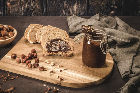 木板上的巧克力酱和榛子面包图片