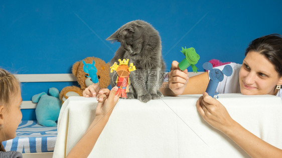 妈和女儿玩木偶戏院和一只累的猫图片