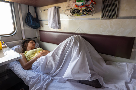 一名年轻女孩睡在火车汽保留座位的下铺图片