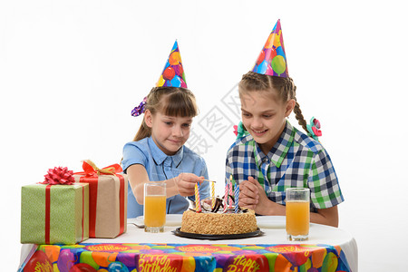 孩子们点蜡烛蛋糕上配一个火柴在生日派对的桌子上图片