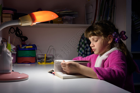 在家做功课的女孩子在桌灯光下做功课图片