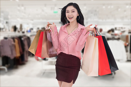 开心的年轻女子在商场拿着购物袋图片