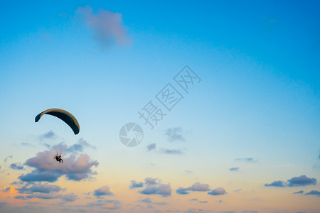 日落时空中飞翔的滑伞图片