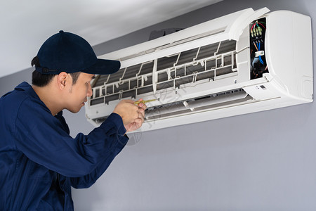 使用螺丝起子机修理室内空调的技术员服务图片