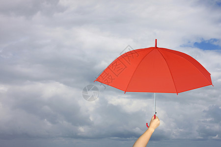 红伞手牵雨保护管理商业概念的关于雨云背景图片