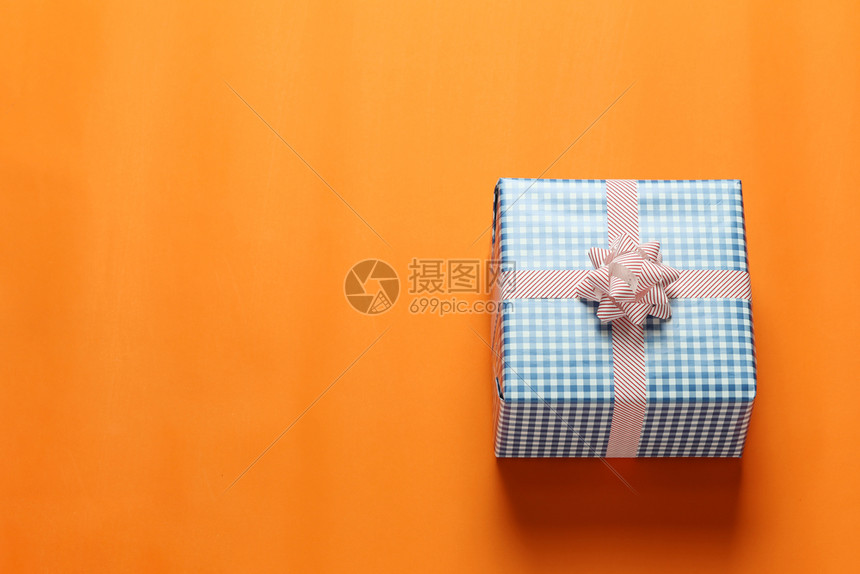 蓝圣诞礼物盒放置在橙色艺术纸地板上并复制工作设计空间重要日子概念图片