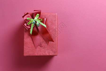 礼品盒和红丝带弓放在艺术纸背景上并有复制空间供你设计图片