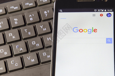 俄罗斯Poltavskaya村2016年月3日智能手机在键盘背景上使用谷歌搜索系统在谷歌的帮助下查找信息在键盘背景上使用谷歌搜索背景图片