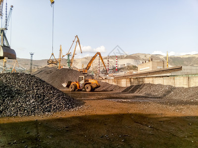 俄罗斯Novorossiysk2017年8月日货物工业港口起重机炭疽石的装载煤炭运输堆积货物工业港口炭石的装载煤堆积背景图片