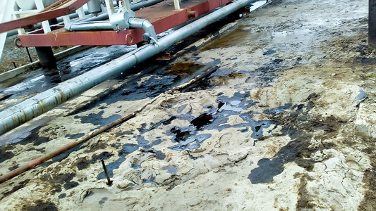 管道和加工设备附近的沙土壤上漏油操作和维修期间漏油管道和加工设备附近的沙地土壤上漏油操作和维修期间漏油图片