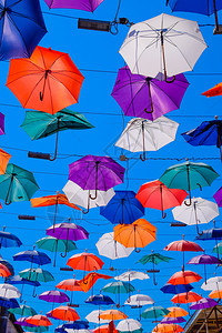 在蓝色天空上挂伞穿过土耳其安塔利亚的卡莱西街在蓝色天空上挂伞在安塔利亚的卡莱西街上行走图片