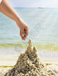 在夏天的沙滩上用湿海建造一座城堡关闭背景图片