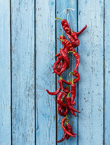 挂在绳子上的辣椒蓝色的老木背景复制空间图片