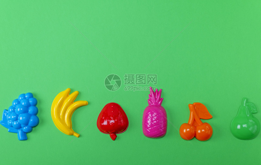 多色塑料玩具水果绿色背景复制空间图片