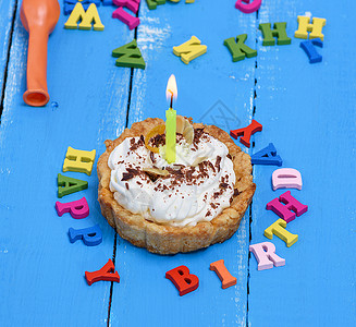 生日板蛋糕加奶油和蜡烛在蓝木背景上生日快乐背景