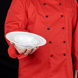 穿红制服的厨师右手握着圆白的汤盘黑底图片