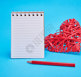直线打开空白笔记本和蓝背景的红心背景图片
