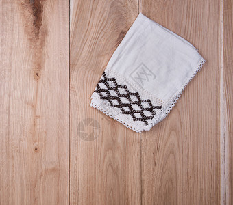 毛巾纹理褐木背景顶视图上的折叠白毛巾背景