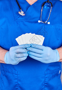 穿着蓝色乳胶手套的男医生持有空白纸名片关闭图片