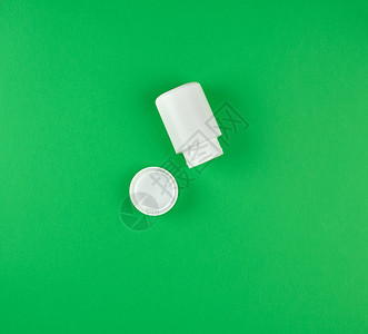 绿色背景靠近封面的白塑料粉片容器图片