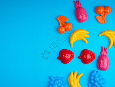 多色塑料玩具水果蓝色背景空间图片
