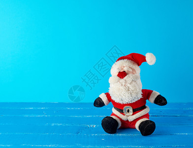 穿着红色西装坐在蓝背景上圣诞节背景图片