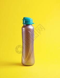 黄色背景的封闭塑料运动瓶关闭图片