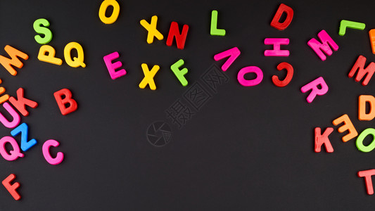 黑色粉笔板上英文字母表的多色塑料字母复制空间返回学校图片