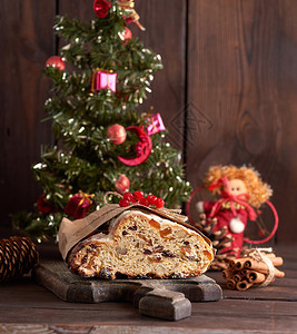 一颗带有坚果和罐头水的传统欧洲蛋糕在棕色木板上涂有糖粉和图片