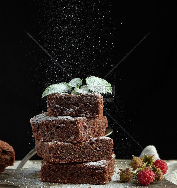 堆成的方面包巧克力蛋糕片上面洒满白糖小粒子飞下来低键图片