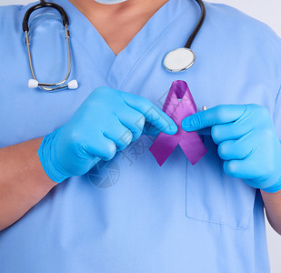 蓝制服和乳胶手套医生戴紫丝带作为早期研究和疾病控制阿尔茨海默氏病细胞纤维化狼疮胰腺癌结骨病的象征图片