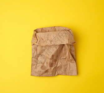 开放的棕色纸袋用于食品包装含黄色背景的油污拒绝塑料袋以保护环境的概念图片